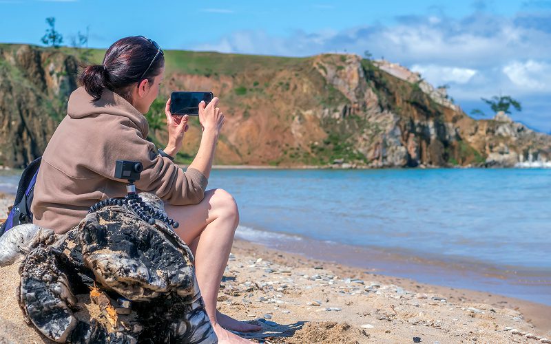 A tourist capturing a photo on a beach